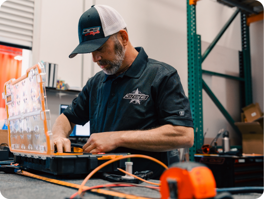 DCB Performance Marine technician assembling components with tools in a workshop, showcasing craftsmanship in boat manufacturing.