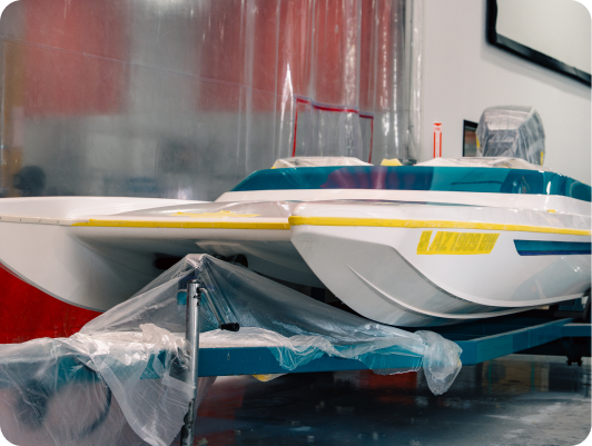 Custom high-performance catamaran boat under construction, featuring protective coverings and precise engineering details, showcasing the craftsmanship of DCB Performance Marine.