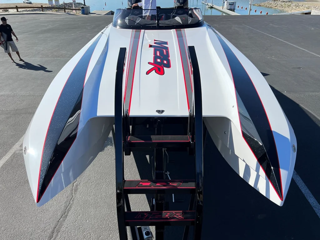 Sleek DCB M28R traditional full deck boat with premium gel coat finish, black windshield, and high-gloss detailing, showcasing aggressive design and performance features.