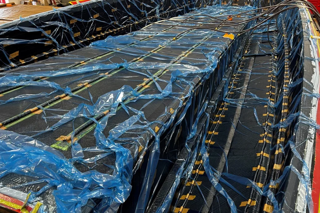 Composite materials layered in a mold with blue vacuum bagging, illustrating the Vacuum Infusion Resin process in boat manufacturing at DCB Performance Marine.